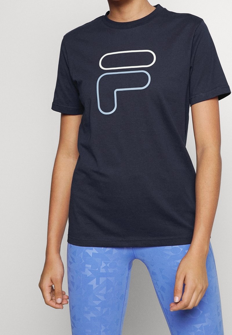 Mörkblå bomull t-shirt med korta ärmar och en vit och ljusblå abstrakt logotyp på framsidan. Avslappnad passform och rundad halsdesign.