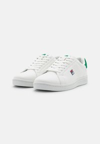 Sneakers bianchi in materiale sintetico liscio, con punta rotonda, lati forati, dettagli verdi sul tallone e suola piatta in gomma.