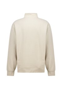 Cream-colored pullover with a high collar, long sleeves, and ribbed cuffs. Made from a soft fabric with a smooth texture, no visible patterns.