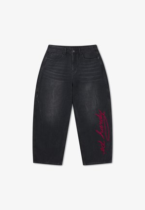 Czarne szerokie spodnie dżinsowe do połowy łydki z wysokim stanem, przednimi kieszeniami i czerwonym kursywą napisem „ed hardy” na prawej nogawce.