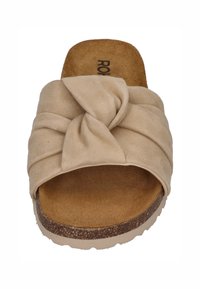 Beige suede sandal with a knotted strap design, open toe, and a textured, cushioned footbed. Features a light brown, slightly raised sole.