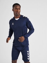 Marine sportshirt met lange mouwen en V-hals; heeft witte chevrons op de schouders en bijpassende shorts; lichtgewicht, sneldrogend materiaal.