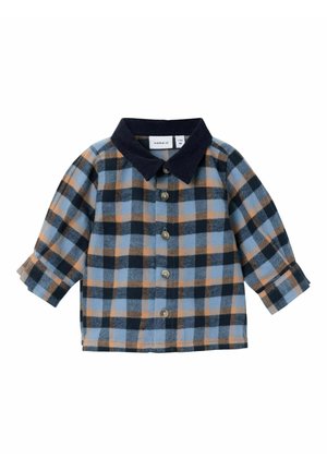 Camicia in flanella a quadri con motivi blu, arancioni e neri; chiusura con bottoni e colletto in corduroy blu scuro; maniche lunghe con polsini arrotolati.