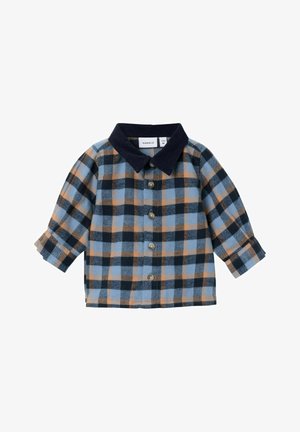 Camicia in flanella a quadri con motivi blu, arancioni e neri; chiusura con bottoni e colletto in corduroy blu scuro; maniche lunghe con polsini arrotolati.