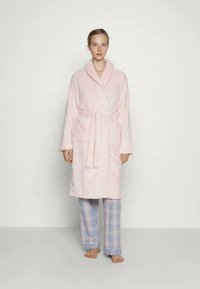 Rozā tekstūrēts halāts ar šalli apkakli, jostu vidukļa daļā un sānu kabatām. Savienots ar zilām un baltām šķērsotām pidžamu biksēm.