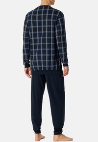 Marineblauw geruit overhemd met lange mouwen en blauwe en grijze strepen, gecombineerd met marineblauwe broek. Comfortabele pasvorm met elastische manchetten en tailleband.