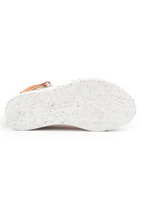 Semelle de chaussure blanche texturée fabriquée à partir de matériaux recyclés, ornée de points de couleur. Fini lisse avec une forme incurvée et des bords doux.