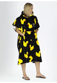 Poncho nero con cappuccio realizzato in tessuto morbido, decorato con vivaci motivi di anatre di gomma gialle e una tasca frontale. Dettagliato con un logo.