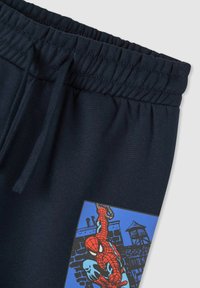 Granatowe bawełniane dresy z elastycznym pasem, z kolorową grafiką Spidermana na niebieskim tle oraz czarnymi brzegami.