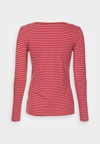 Maglietta rossa a maniche lunghe con righe orizzontali bianche; presenta un collo rotondo e un design aderente. Tessuto morbido e elasticizzato.