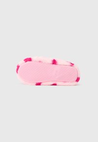 Pink fuzzy slipper with a rubber outsole, featuring a textured grip and pink and fuchsia striped pattern along the edge.