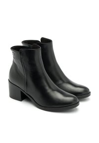 Botas de tobillo de cuero negro con punta redonda, tacón bajo en bloque y cremallera lateral. Textura suave con una sutil marca en el tacón.