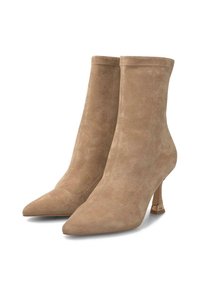 Botines de ante beige con puntera afilada y tacones de aguja esbeltos, que presentan un pequeño detalle dorado cerca de la base.