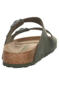 Green sandal with two adjustable strap buckles, cork footbed, textured material, and a flexible rubber sole. Open-back design for easy wear.