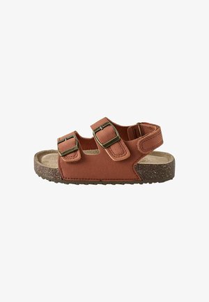 Sandale en cuir marron pour enfant avec deux sangles réglables à boucle et une semelle en liège texturée.