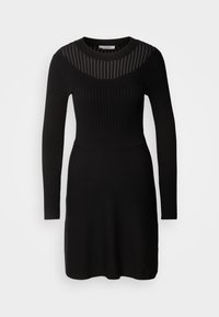 Robe noire cintrée à manches longues avec une texture côtelée sur le dessus et un panneau rayé transparent sur le haut de la poitrine et le décolleté.