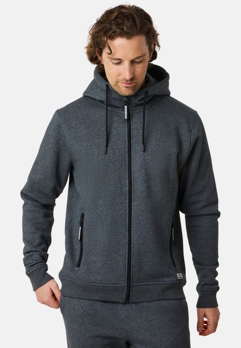 Grå zip-up hoodie med huva, framfickor och snoddar. Tillverkad av ett mjukt, texturerat tyg med en avslappnad passform.