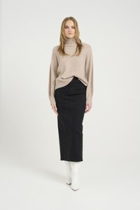 Beige genser med høy hals og løs passform, kombinert med et svart denim midi-skjørt og hvite spisse ankelstøvler. Enkelt design og glatt tekstur.