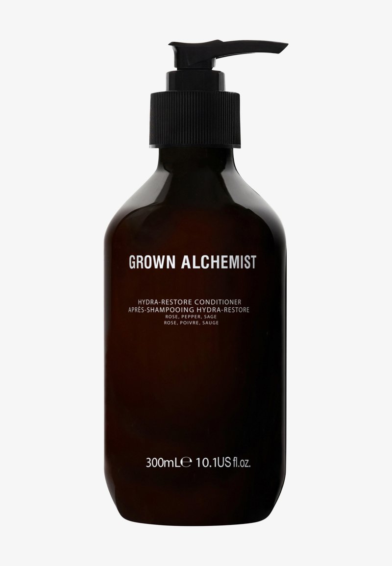 Donker amber glazen fles met een zwarte pompdeksel. Het etiket toont "Grown Alchemist Hydra-Restore Conditioner" in witte tekst. Capaciteit van 300 ml.