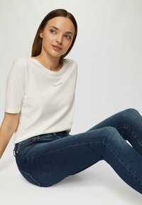 White short-sleeve t-shirt with a round neckline and "S. OLIVER" logo, paired with dark blue denim jeans. Smooth texture, casual fit.