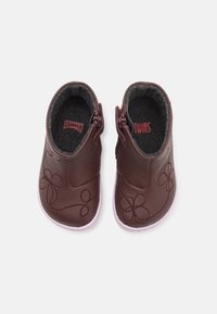 Botas de cuero burdeos hasta el tobillo con bordado floral, suela en un tono rosa claro en contraste, cierres de cremallera y un suave forro gris.