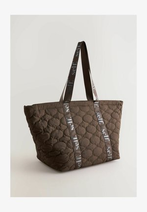 Braune gesteppte Tragetasche mit abgerundeten, gesteppten Mustern und doppelten Stoffgriffen, die einen wiederholten "self."-Text in Grau zeigen.