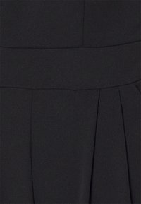 Musta mekko, jossa on sileä pinta, sisältäen rakenteellisen vartalon ja pleatattu hame. Yksinkertainen muotoilu ilman näkyviä kuvioita tai tarvikkeita.