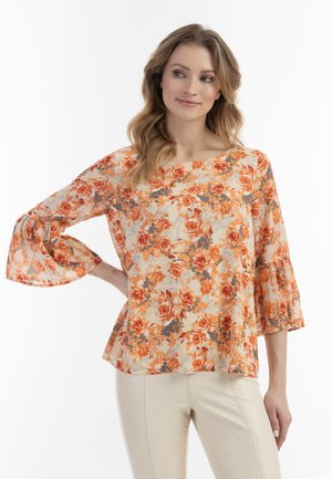 Sund blomstret bluse med klokkeærmer, med et orange og beige mønster. Stoffet har en let, transparent tekstur og en afslappet pasform.