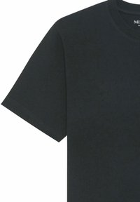 T-shirt noir uni à manches courtes, col rond et petite étiquette de marque blanche imprimée à l’intérieur du col.