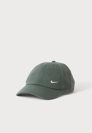 Gorra de béisbol Nike de color verde oscuro con visera curva y logo Swoosh blanco en el centro delantero sobre fondo blanco liso.