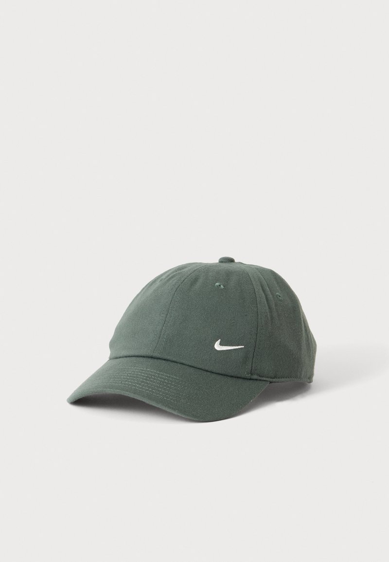 Mørkegrøn Nike baseballkasket med buet skygge og hvidt Swoosh-logo midt på fronten mod en ensfarvet hvid baggrund.