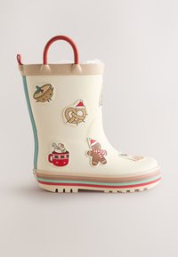 Cremefarbener Gummistiefel mit rotem Griff, verziert mit niedlichen, weihnachtlich inspirierten Aufklebern. Die Sohle hat bunte Streifen und ein strukturiertes Profil.