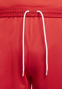 Pantalones cortos deportivos rojos con cordón blanco, cinturilla elástica y textura de tela suave. No hay patrones ni acentos adicionales visibles.