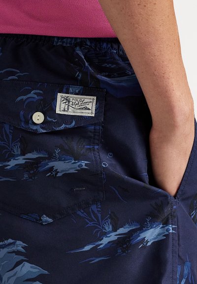 Jūras sniegts šorti ar zilu tropu rakstu, elastīgu jostu, kabatas ar pogu un birku ar uzrakstu "Polo Ralph Lauren Swimwear."