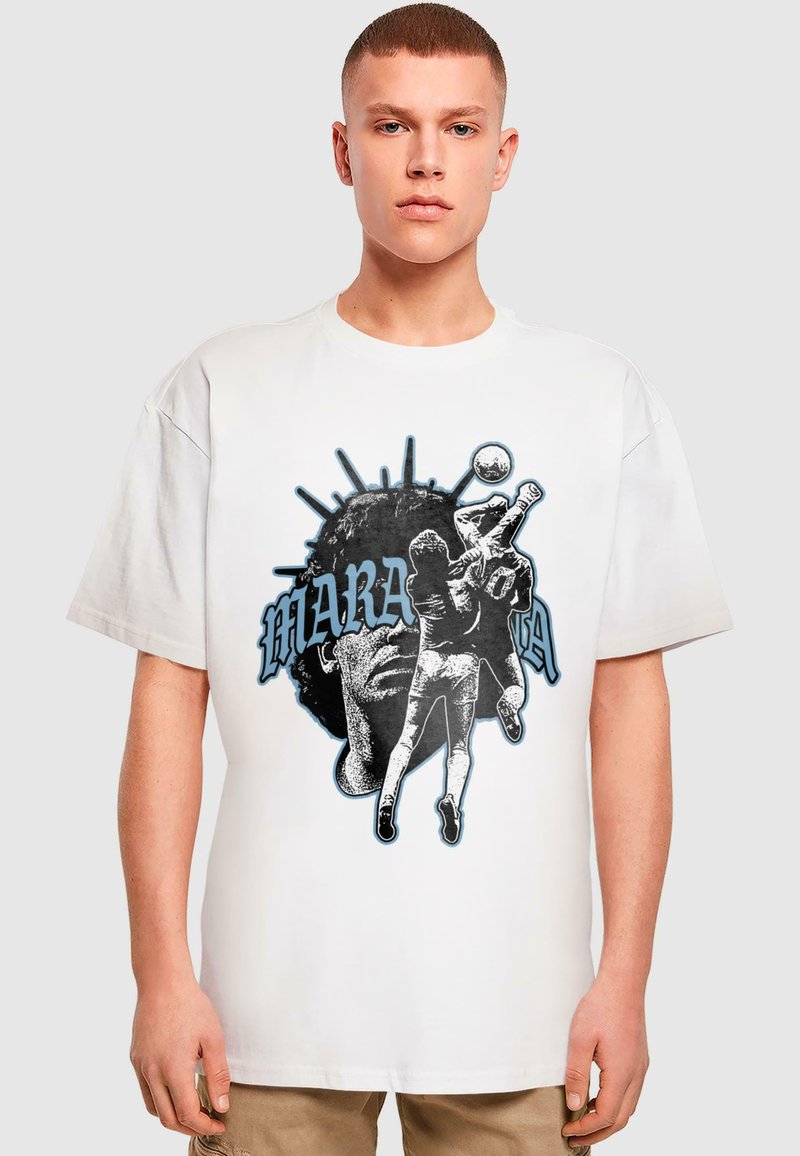Hvid bomulds t-shirt med et grafisk design, der viser en silhuet af en fodboldspiller, teksten "MARADONA" og en stiliseret hovedillustration.