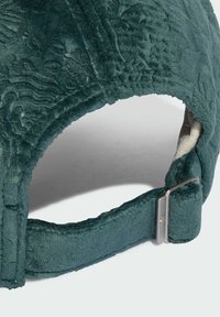 Gorra de color verde oscuro con patrones florales en relieve, fabricada con un material texturizado y un cierre de metal en una correa ajustable en la parte trasera.