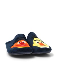 Zapatillas de casa de felpa azul marino que presentan rostros bordados de personajes de dibujos animados en naranja y amarillo, con cabello negro y ojos grandes.