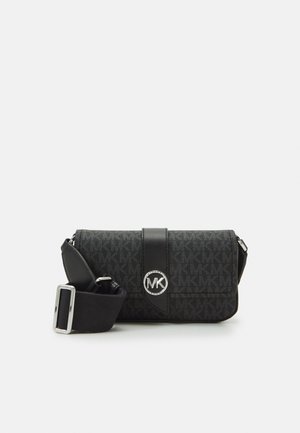 Sort crossbody taske med justerbar rem, MK monogram mønster og sølv MK logo på frontklaplukningen.
