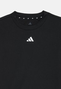 Czarna sportowa koszulka z okrągłym dekoltem, z białym logo Adidas na piersi oraz subtelnymi białymi akcentami wewnątrz kołnierza.