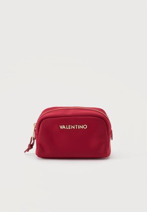 Pieni suorakulmainen punainen meikkipussi, jossa on kultainen vetoketju ja Valentino-logo edessä, yksinkertaisen valkoisen taustan edessä.