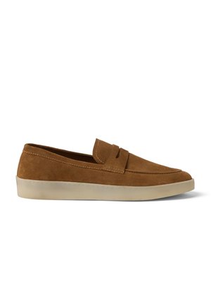 Mocassin en daim marron à enfiler avec surpiqûres moc toe et semelle en caoutchouc blanche, présenté en profil latéral sur fond blanc.