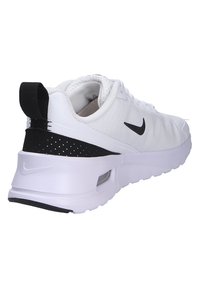 White athletic shoe with a textured mesh upper, black accents, and a thick white sole featuring a visible air unit at the heel.