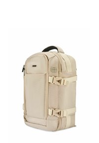 Jasno beżowy plecak wykonany z trwałego materiału, z boczną rączką, regulowanymi paskami, dwoma bocznymi klamrami oraz kieszeniami zapinanymi na zamek.