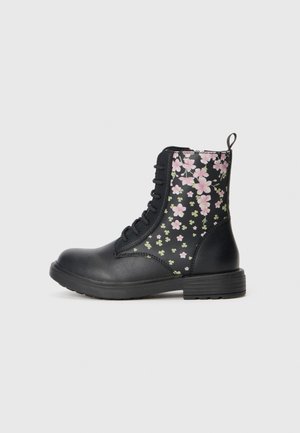 Schwarze Kampfstiefel mit floralem Muster in Pink und Grün. Mit Schnürsenkeln, runder Zehenform und strukturiertem Sohlenprofil. Ungefähr knöchelhoch.