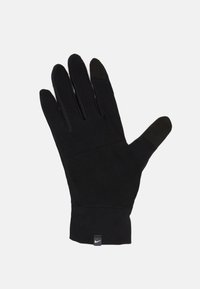 Gant de sport noir en tissu extensible, doté d'un design ajusté, d'un bout de doigt sensible au toucher et d'une petite étiquette Nike au poignet.