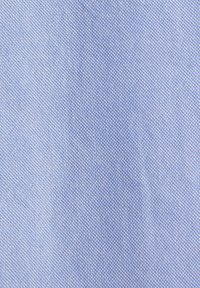 Gros plan sur un tissu bleu clair texturé avec un petit motif tissé serré formant une apparence en forme de grille.