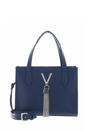 Sac à main en cuir texturé bleu marine avec double poignées, bandoulière amovible et détail métallique en forme de V argenté avec chaînes à pompons sur le devant.