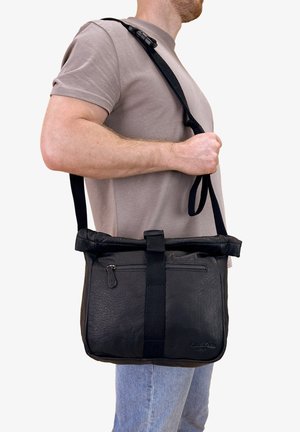 Black leather messenger bag with a textured finish, fold-over top, adjustable strap, and a zippered front pocket.