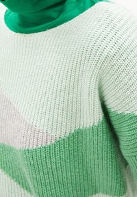 Pull en tricot aux nuances vertes et pastel avec des rayures horizontales. Confectionné en fil doux, il présente une coupe décontractée et une surface texturée.