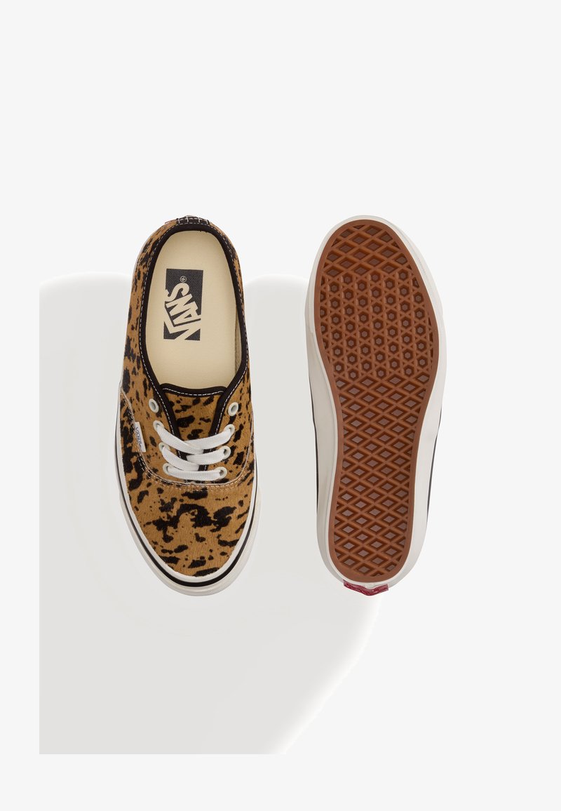 Paire de baskets basses Vans avec imprimé léopard marron et noir, lacets blancs, et semelle en caoutchouc à motif gaufré, une chaussure vue de dessus, une semelle vue.